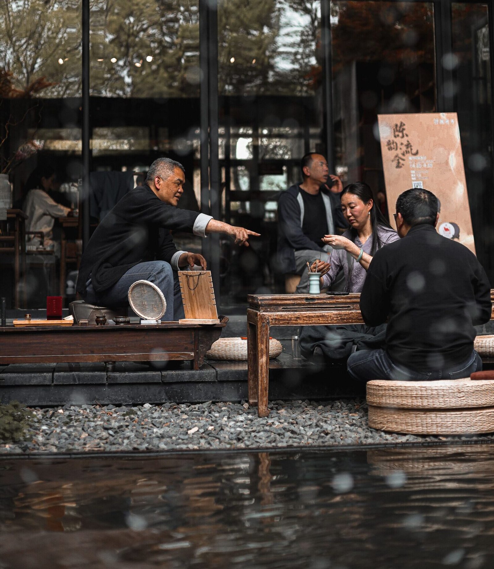Men engaging in a traditional Japanese tea ceremony inside a serene tea house.